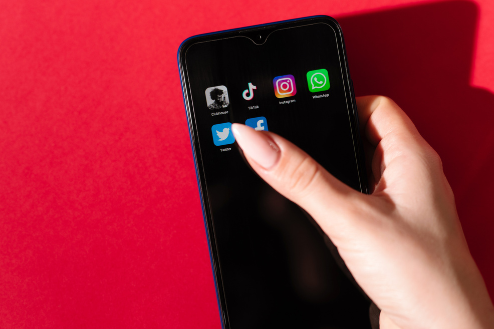 VICHUGA, RUSSIA - FEBRUARY 17, 2021: Woman's Hand Taps on a Smartphone Screen with Trending Social Apps